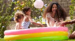 Children playing in a Splash Pool, showing a great water play activity idea for any nursery setting.