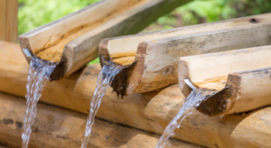 Water running through guttering making a water wall that is used by children in an Early Years setting